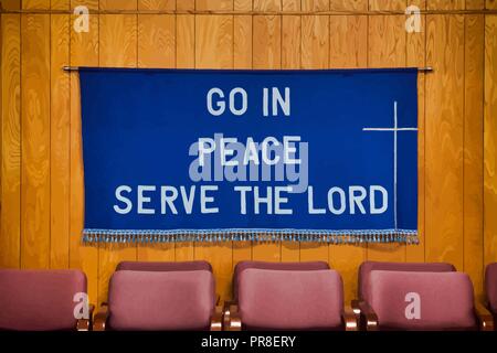 `Go in Peace Serve the Lord` written on Dark Blue Cloth with white cross on the right side, tassels all along the bottom of the cloth. Stock Vector